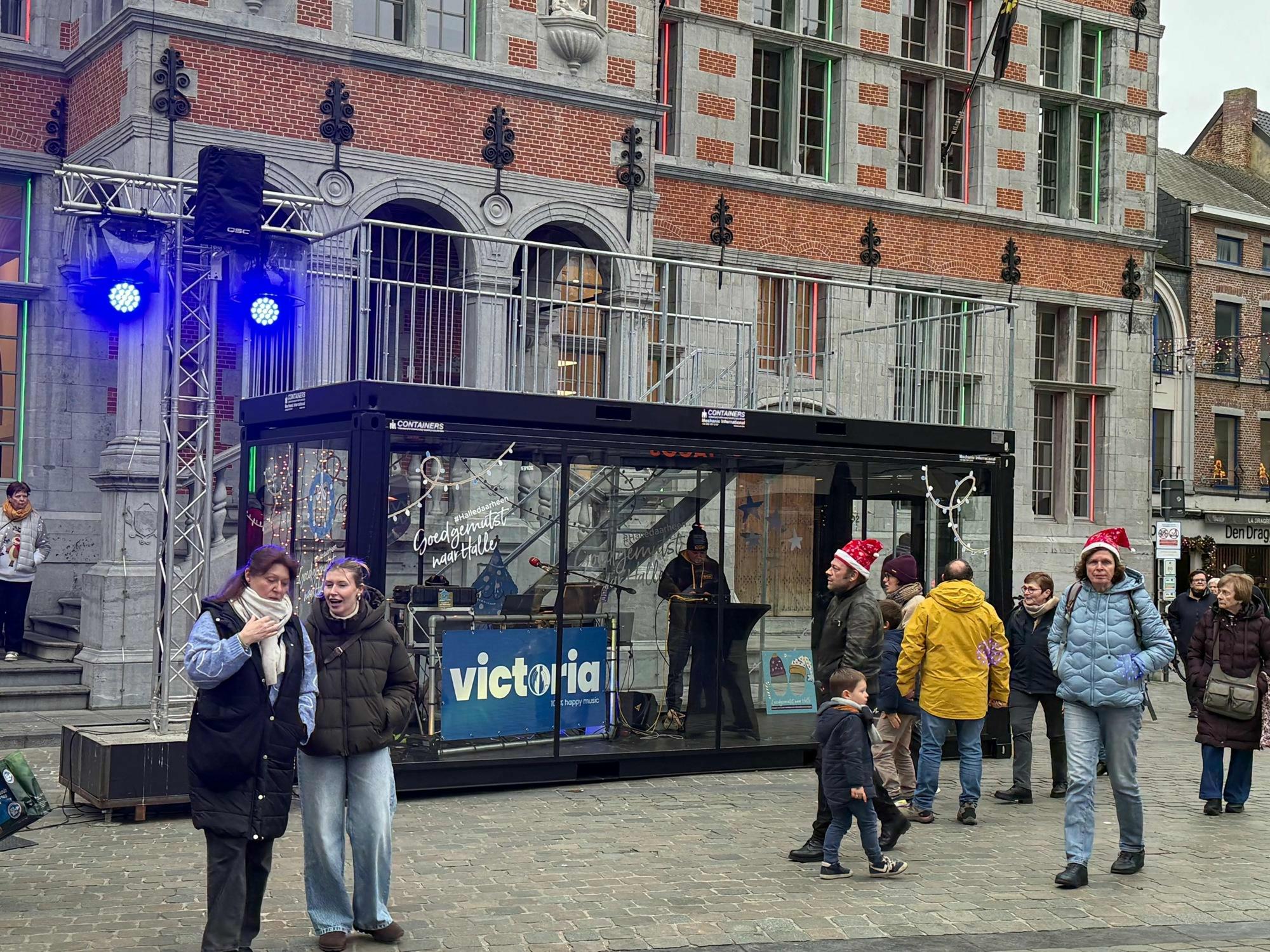 Verglaster Container met individueller Folierung auf dem Weihnachtsmarkt in Halle vor der Kulisse des historischen Rathauses.